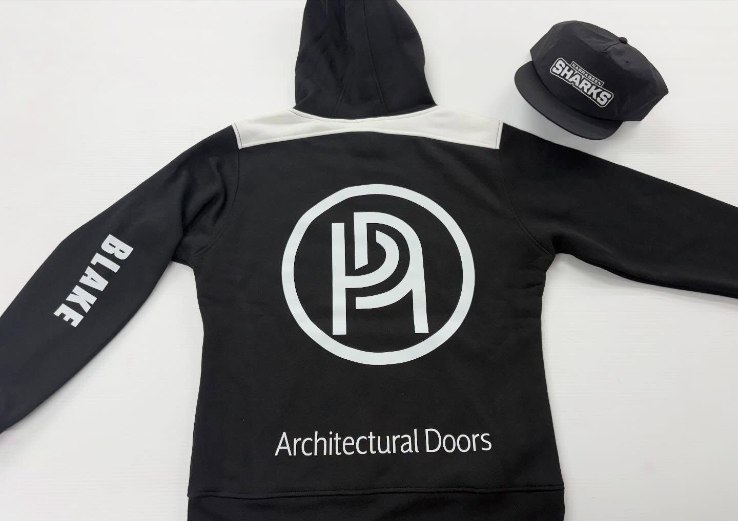 Architectural Doors branded hoodie and Narrabeen Sharks cap